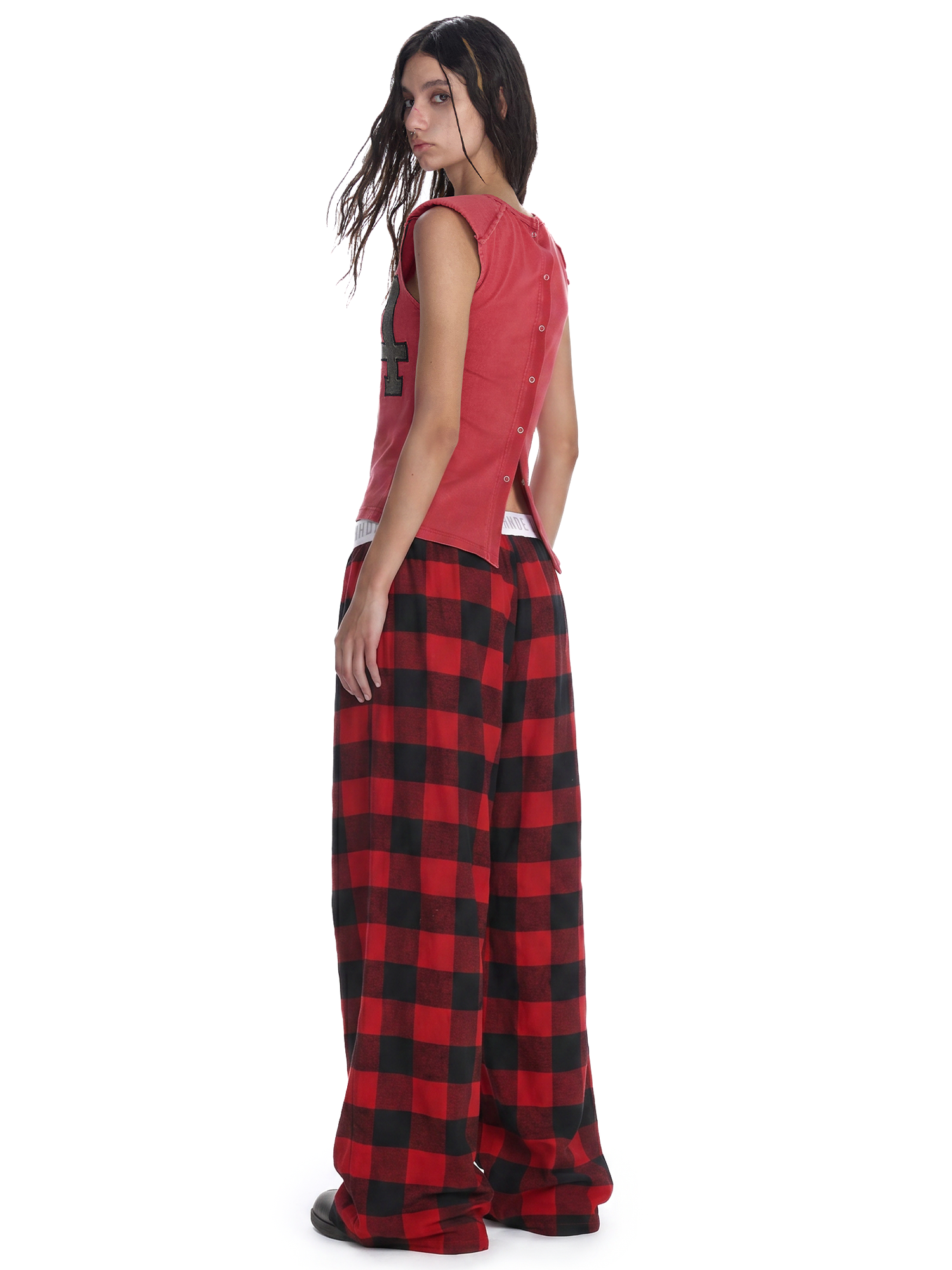 Rear view of red checkered wide-leg trousers on model showcasing the relaxed streetwear vibe.