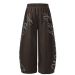 Back view of dark brown oversized joggers with elastic waistband and wide leg opening.
