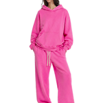 Woman wearing oversized bright pink hoodie and matching sweatpants loungewear set