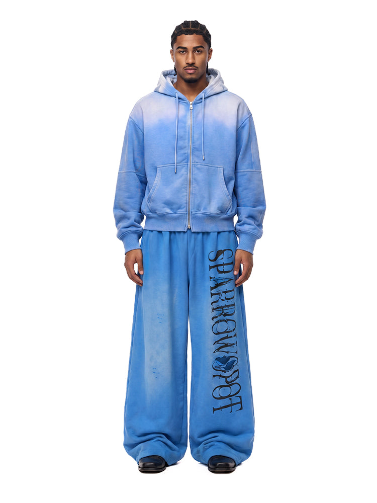 Male model wearing FDR Studios blue techwear full-zip hoodie and oversized joggers.