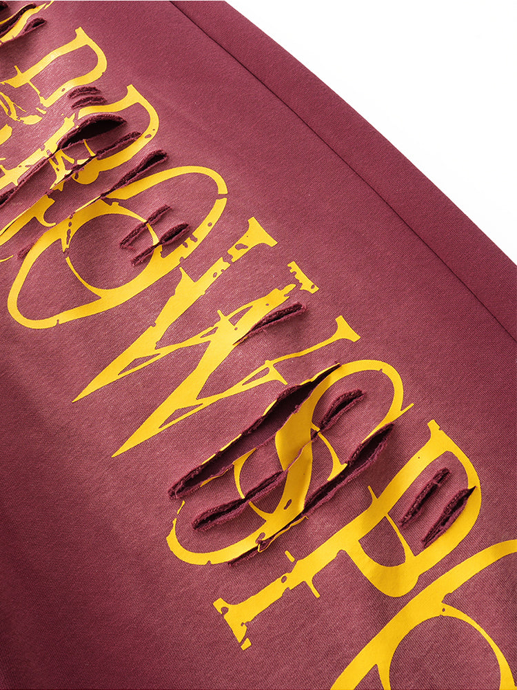 Close-up of yellow "FDR" graphic print on burgundy high-street fabric.
