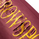 Close-up of yellow "FDR" graphic print on burgundy high-street fabric.