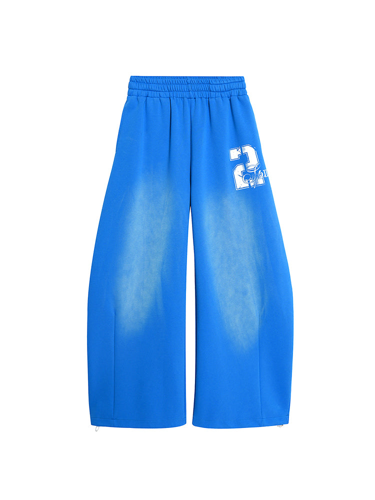 Front view of bright blue wide-leg track pants featuring a white graphic print with the number "2" on the leg.