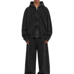 Man posing in a charcoal black oversized streetwear zip-up hoodie and loose fit joggers.
