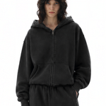 Woman wearing a washed black oversized zip-up hoodie and sweatpants lounge set.