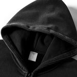 Close-up of a black hoodie with a brand label on a white background