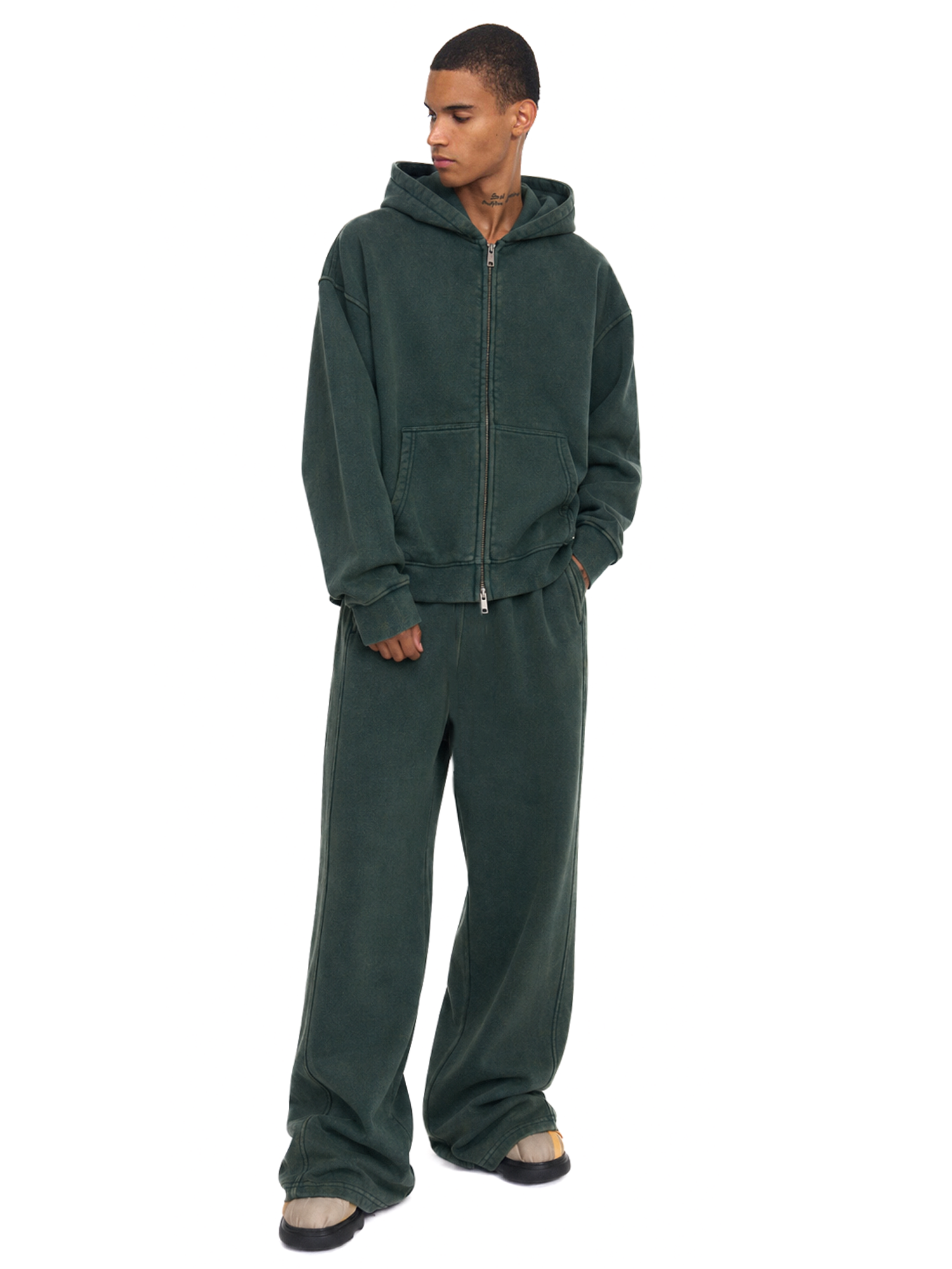 Male model wearing a forest green full-zip hoodie and matching baggy sweatpants.