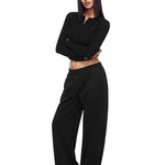 Ganzkörperaufnahme eines weiblichen Modells, das die schwarzen Weitsweathosen und das passende schwarze Crop-Top von FDR Studios trägt und ein komplettes minimalistisches industriestilisches Lounge-Set vorführt. Saubere Linienästhetik für moderne Streetwear.