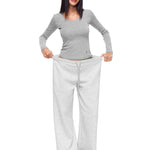 Full-body photo of a model showcasing the Heather Grey variant of FDR Studios wide-leg sweatpants, paired with a matching long-sleeve crop top. A versatile and breathable women's loungewear essential.