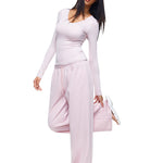 Full-body shot of a model wearing soft pink wide-leg sweatpants and matching long-sleeve top, demonstrating a feminine and stylish interpretation of women's comfortable loungewear.