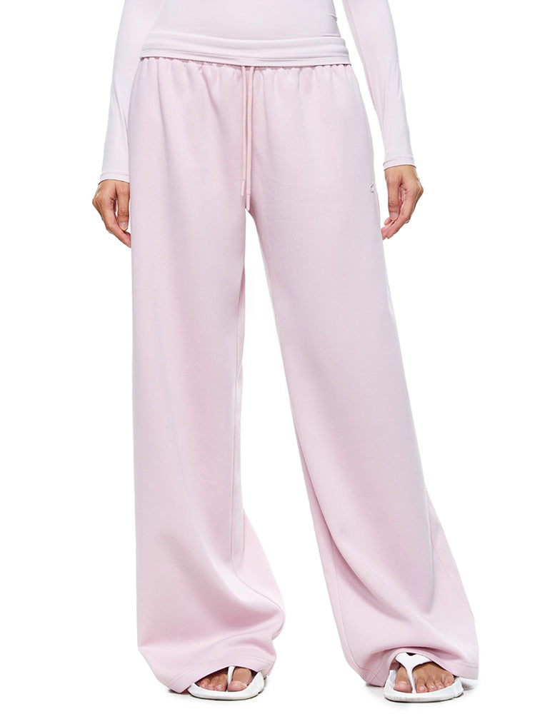 A direct front view of a model showcasing the complete FDR Studios soft pink wide-leg sweatpants set. Highlighting the comfort and clean silhouette of this versatile loungewear.