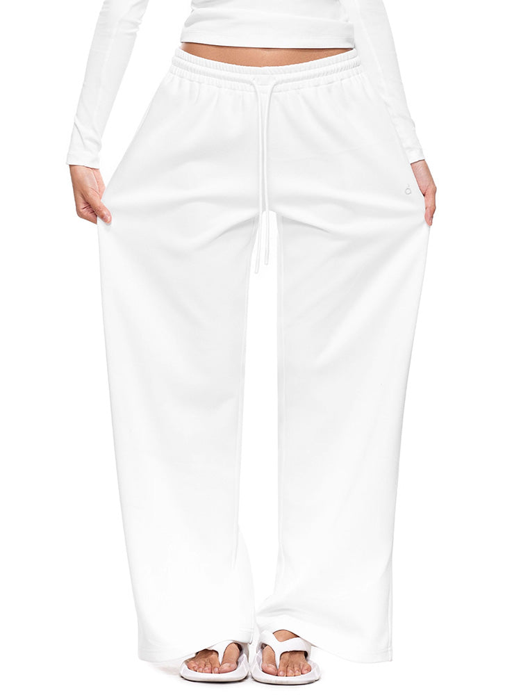 Full-body shot of a model wearing crisp white wide-leg sweatpants  illustrating a clean, minimal loungewear pants with a relaxed, premium feel.