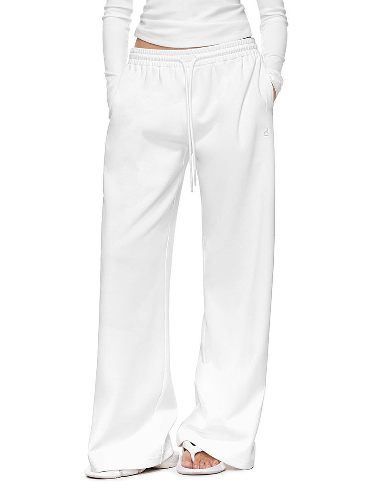 Full-body shot of a model wearing crisp white wide-leg sweatpants  illustrating a clean, minimal loungewear pants with a relaxed, premium feel.