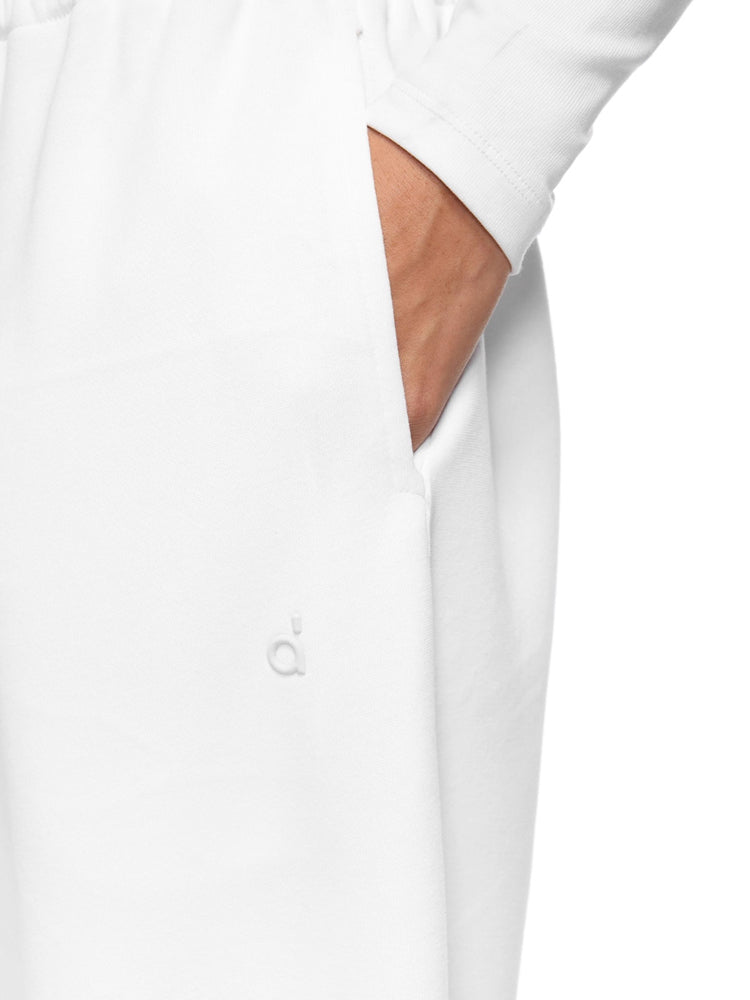 Full-body shot of a model wearing crisp white wide-leg sweatpants with pocket detail