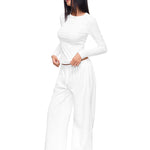 Full-body shot of a model wearing crisp white wide-leg sweatpants and matching long-sleeve top, illustrating a clean, minimal loungewear set with a relaxed, premium feel.