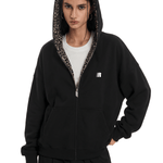 Person wearing a black hoodie with leopard print lining on a white background