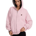 Person wearing a pink hoodie with a leopard print hood on a white background
