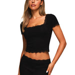 Close-up of black short sleeve square neck crop top with scalloped lace hem.