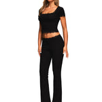 Front perspective of high-waisted flare leg trousers and matching crop top in black.