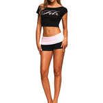 Full-length shot of a model in a light pink FDR off-shoulder top and matching shorts set.