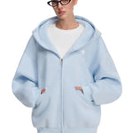 Front view of model in sky blue baggy hoodie with kangaroo pockets, clean modern streetwear.