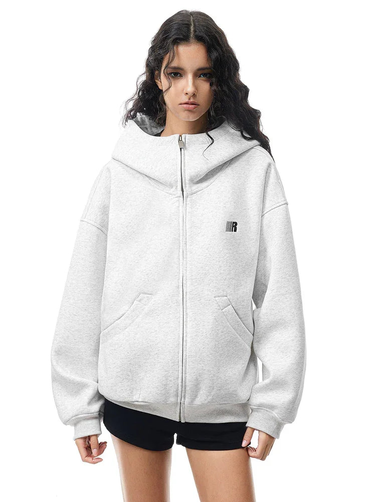 Model wearing light gray structured hoodie, presenting a bright Y2K high-street fashion look.