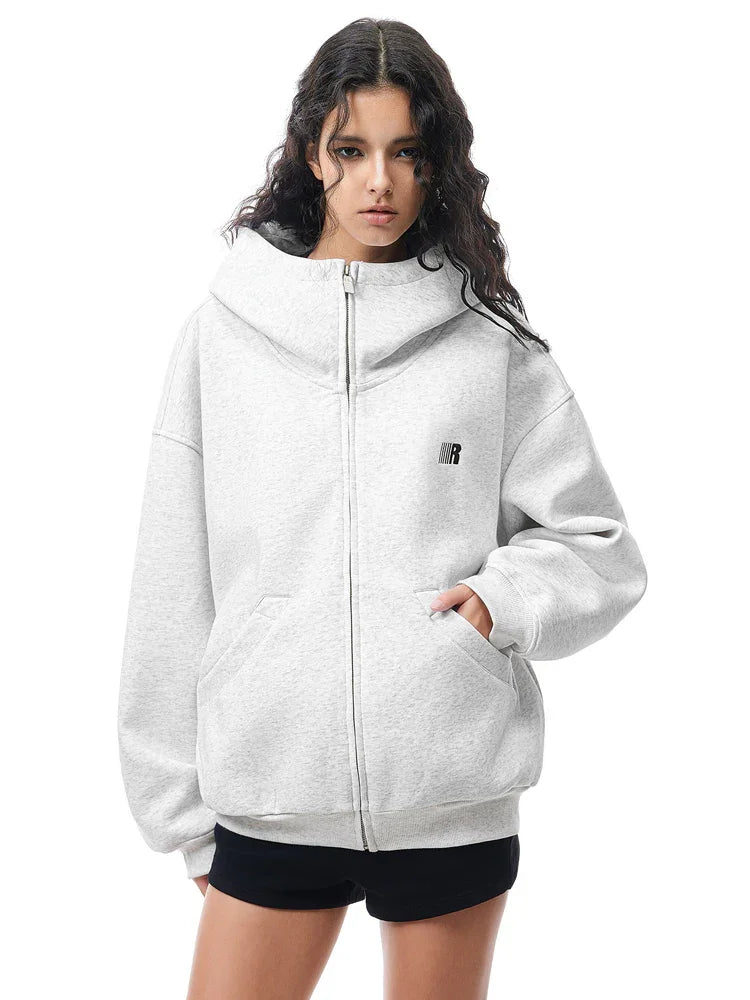 Model wearing light gray structured hoodie, presenting a bright Y2K high-street fashion look.