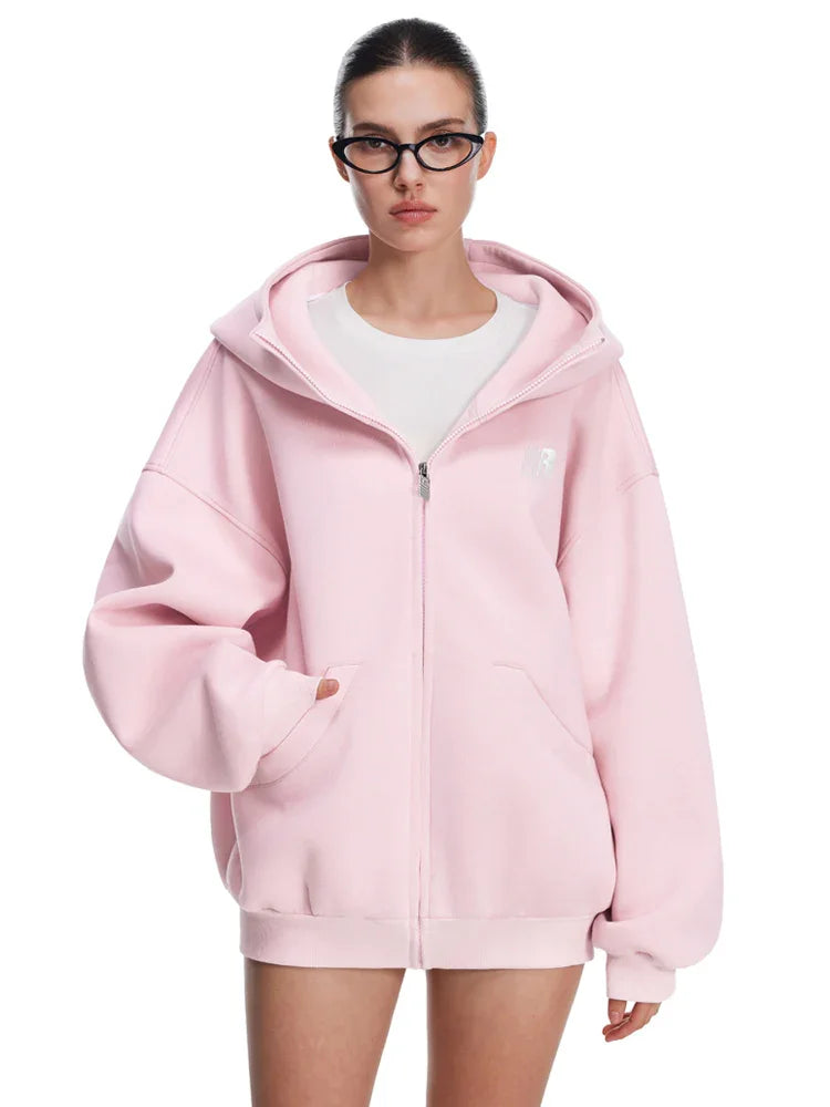 Front view of model wearing pastel pink oversized zip-up hoodie, perfect for spring/summer streetwear.