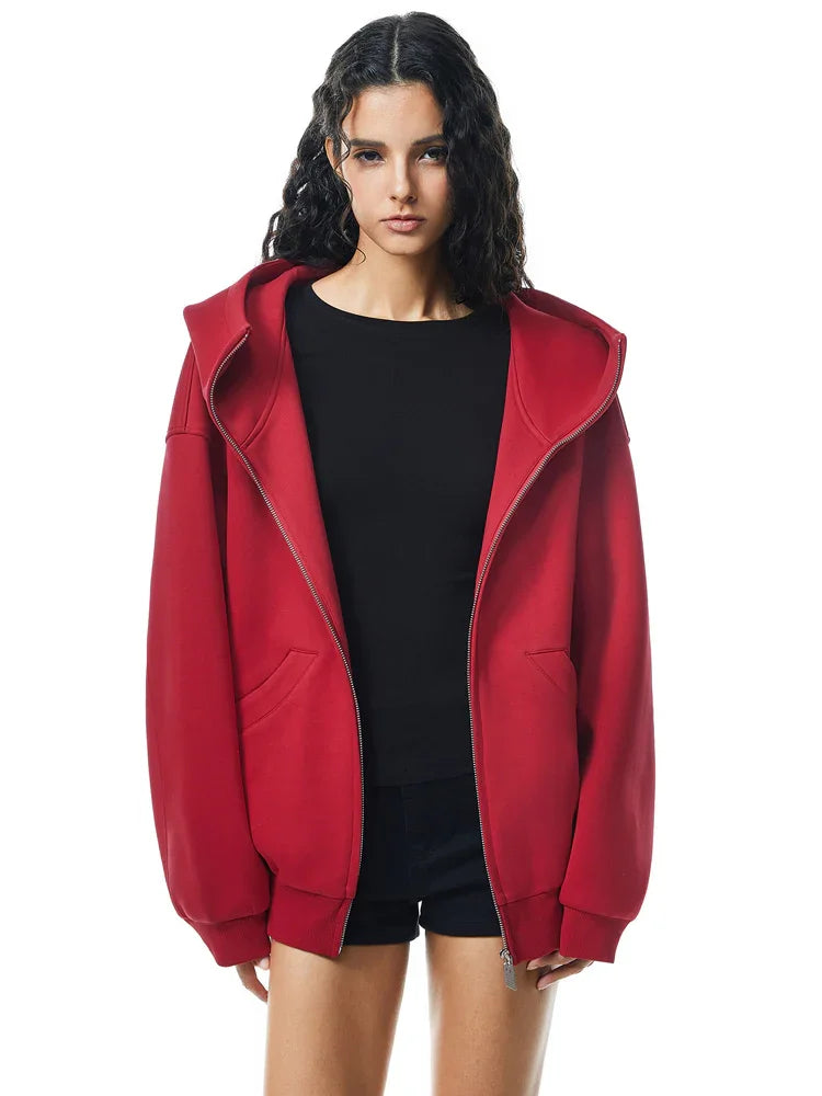 Model in vibrant red high-neck zip hoodie, adding a bold pop of color to the edgy silhouette.