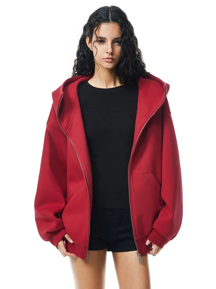Side view of red oversized hoodie on model, showcasing dropped shoulders and loose fit back.