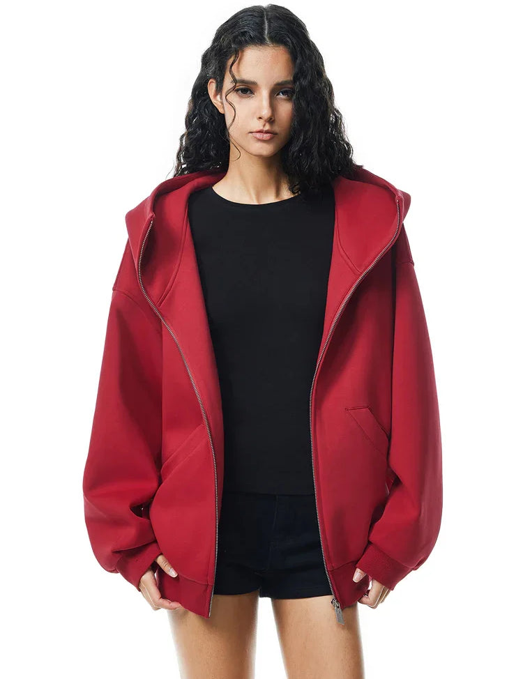 Side view of red oversized hoodie on model, showcasing dropped shoulders and loose fit back.