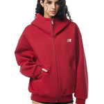 Side view of red oversized hoodie on model, showcasing dropped shoulders and loose fit back.
