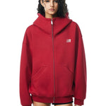 Side view of red oversized hoodie on model, showcasing dropped shoulders and loose fit back.